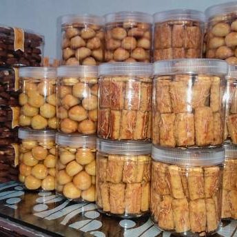 A pile of jar filled with cheese cookies called 'Kastengel',  cookies stuffed with pineapple jam called 'Nastar' and choco peanut cookies were ready to sale